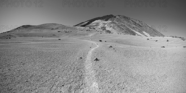 Hiking trail and rock formations, volcanic landscape in El Teide National Park, behind it the Pico