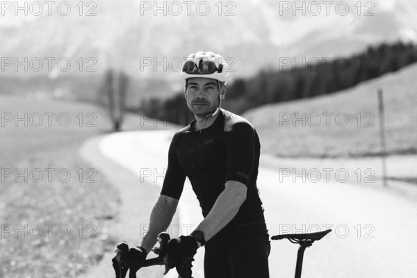 Road bike rider in spring near Halblech in the Allgäu in front of a picturesque backdrop of the
