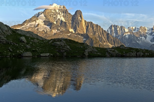 Reflection of the peaks Aiguille Verte and Aiguille du Dru in the mountain lake Lacs des Chéserys