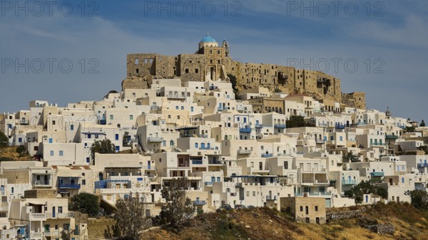 Historic fortress above a settlement of white houses under a blue sky, Querini Castle, Chora,