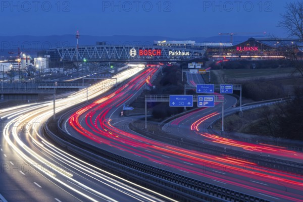 A8 motorway at Stuttgart Airport in the evening. Heavy traffic, lanes of light. Modern architecture