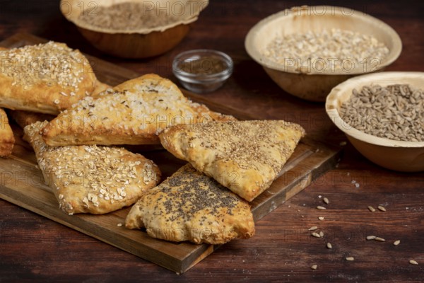 Freshly baked dough triangles sprinkled with sunflower seeds, poppy seeds, sesame seeds, oat flakes