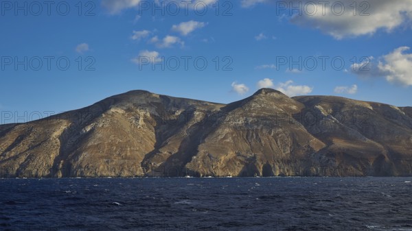 View of a rocky coastline under a clear blue sky, Kassos Island, neighbouring island of Karpathos,