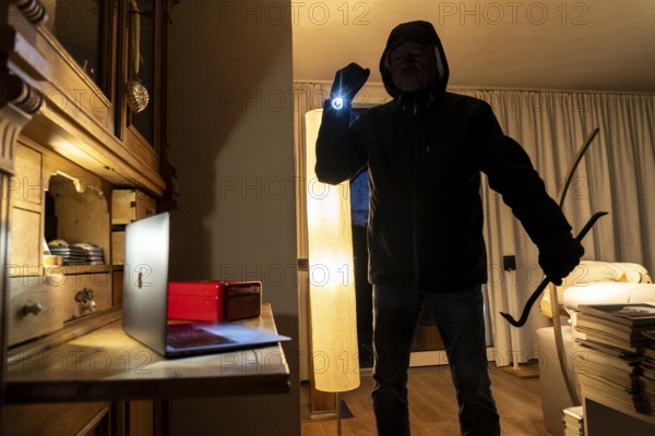 Symbolic image of a burglary, perpetrator has broken into a flat from the garden side and is