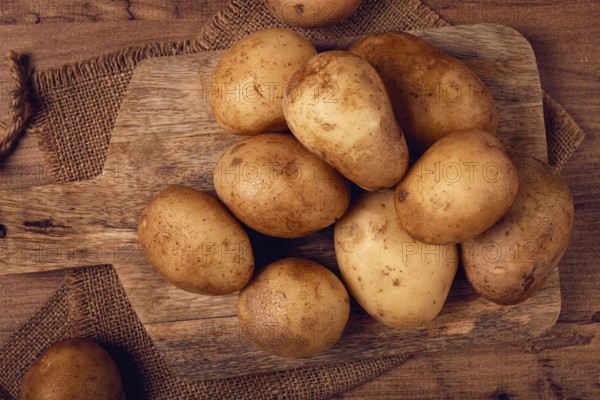 Raw potatoes, scattered on a chopping board, close-up, no people