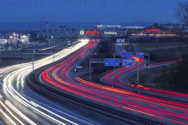 A8 motorway at Stuttgart Airport in the evening. Heavy traffic, lanes of light. Modern architecture