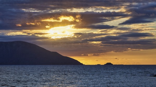 A dramatic sunset with clouds over the sea, an island on the horizon at dusk, sunset, Kassos,