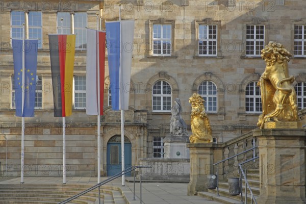 Town hall built in 1909 with flags and two golden lion figures, EU flag, German national flag,