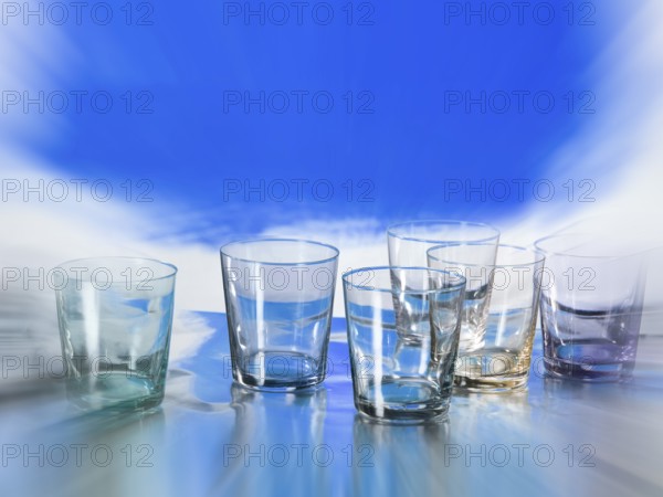 Various glasses on silver foil, blue colour area behind, zoom effect, studio shot