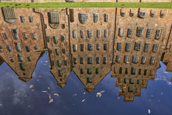 Reflections on the water surface of the Trave, salt warehouse, historic brick buildings, Hanseatic