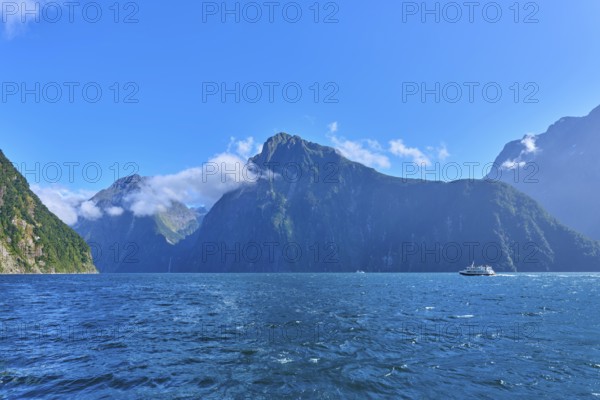 Boats on blue waters in front of majestic mountains, summer, Milford Sound, Te Anau, Fiordland
