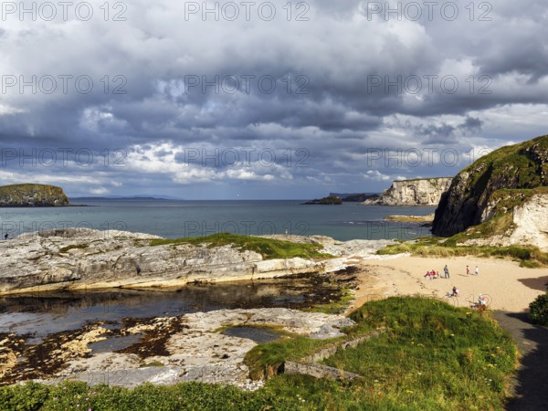 Rocky coast with sandy beach in summer, Ballintoy Harbour, Causeway Coastal Route, Antrim, Northern