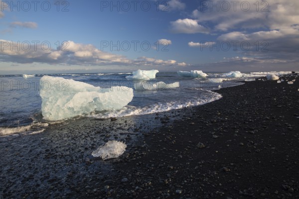 Little icebergs and crushed ice on the black beach at Joekulsarlon glacial lake