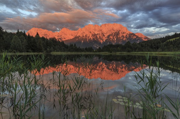 Mountains and clouds reflected in lake, evening light, cloudy mood, summer, Luttensee, Mittenwald,