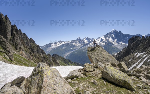 Mountaineer standing on a rock, mountain landscape with mountain peak Aiguille Verte, Mont Blanc