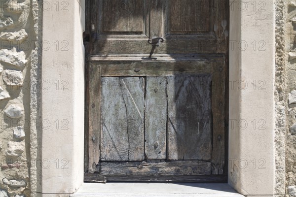 Weathered wooden door in an old, stone arched frame, Mediterranean atmosphere, Provence, France,