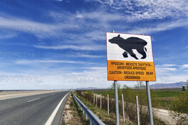 Bilingual warning sign on motorway, caution, drive slowly, bears crossing the road, Western
