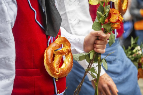 Parade of historically costumed guild members, guild member wearing a pretzel around his neck,