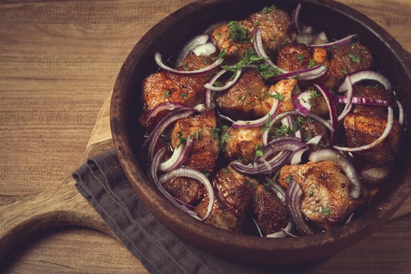 Fried meat, pork kebab, ketsi in a clay pan, with red onions and herbs, homemade, no people