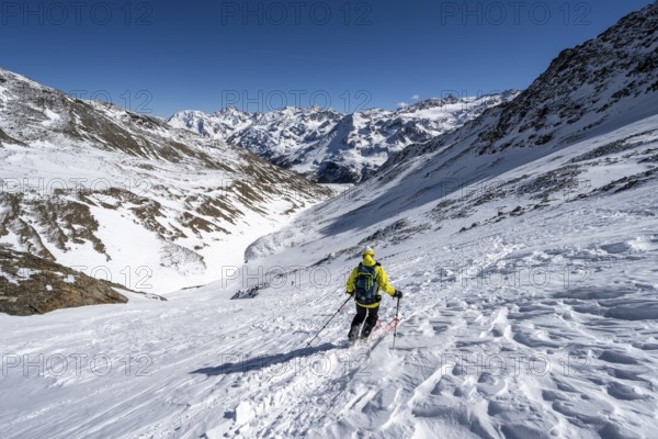 Ski tourers descending from the summit of the Madritschspitze, mountain panorama with snow-covered