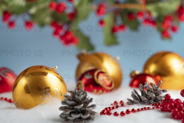 Christmas decoration with gold and red baubles on snow effect