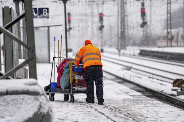 Winter weather, heavy snowfall, platform at Essen central station, railway staff, service team,