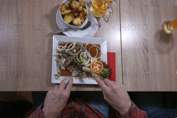 Pork brawn with onion and fried potatoes served in a Franconian restaurant, Bavaria, Germany,
