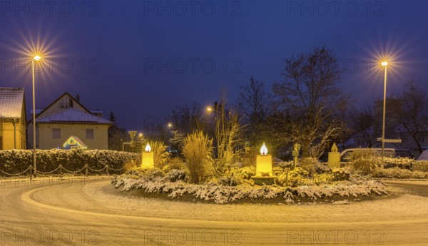 Advent candles at the roundabout, illuminated, snowy and at dusk, Coswig, Saxony, Germany, Europe