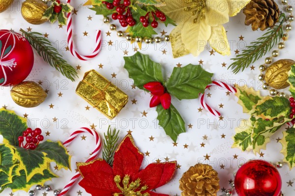 Christmas decorations, such as fir branches, baubles, nuts, holly branches on a white background