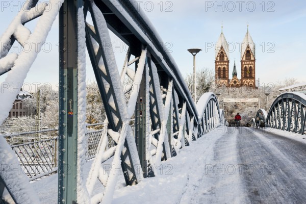 Bridge with snow and ice and cyclists, Blue Bridge and Stühlinger Church, Freiburg im Breisgau,