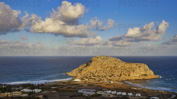 Coastal view with large rock formation and clouds in the blue sky, Acropolis Hill, Arkasa, West