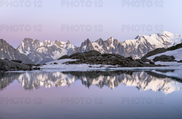 Evening mood with pink evening sky, mountain landscape at sunset, water reflection in Lac Blanc,