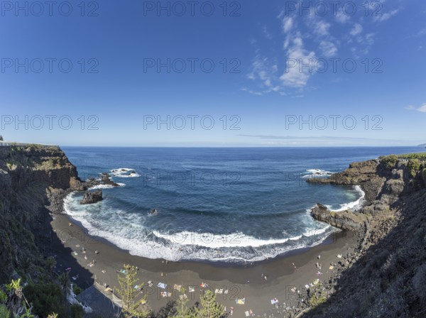 The lava beach lined with bathers, Playa del Bollulo, near Puerto de la Cruz, Tenerife, Canary