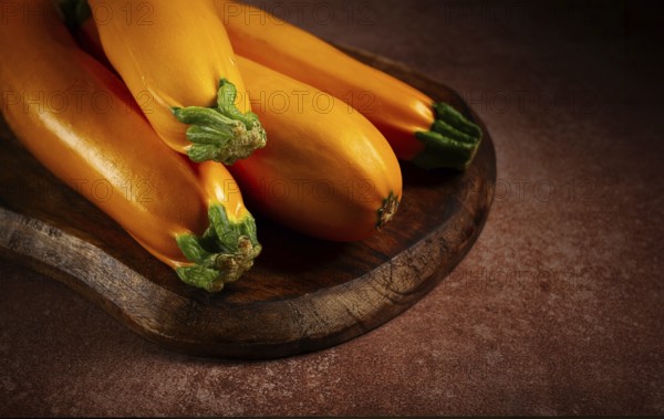 Yellow zucchini, fresh, raw, on a wooden chopping board, no people