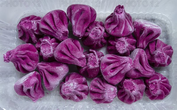Freshly frozen beetroot khinkali, in a container, top view, no people