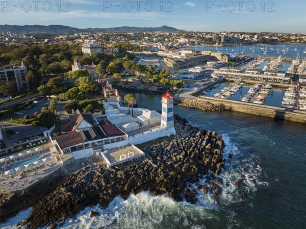 Aerial view of Santa Marta lighthouse and Cascais marina with moored yacht boats with Cascais