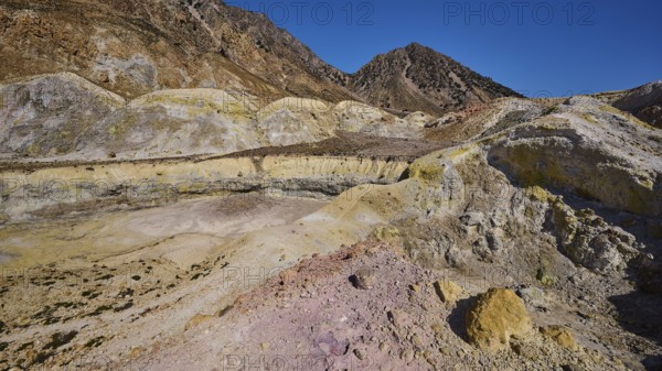 Yellow and brown crater landscape with hills and cloudless sky, volcanism, volcanic island,