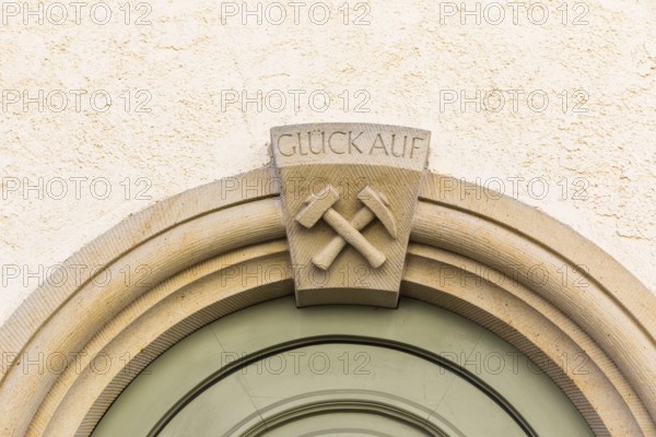 Mallet and iron and inscription Glück Auf, on the portal of a residential building at Pfarrgasse 16