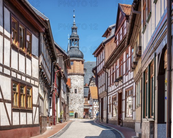 Alley with half-timbered houses and cobblestones in the historic old town, Saigerturm tower in the