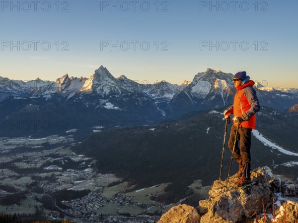 Mountaineers on the summit of Rauher Kopf at sunrise, behind them the Berchtesgaden Alps,