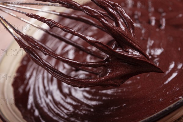 A bowl of chocolate dough, a whisk for whipping, baking, structure and consistency, homemade, top