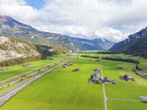 Wide valley with green meadows and a road, framed by mountains, Lake Brienz, Switzerland, Europe