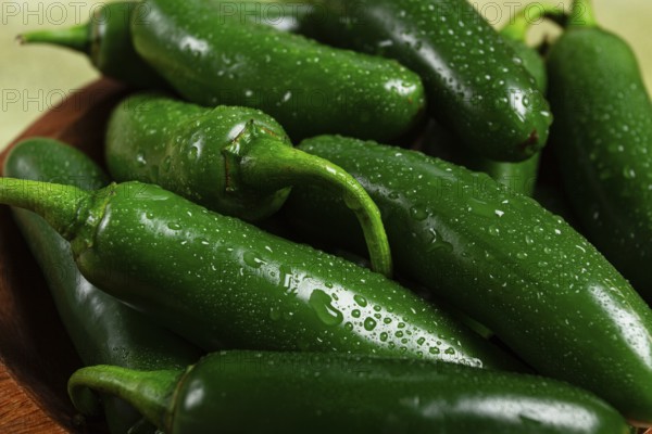 Fresh padron pepper, raw, in a wooden bowl, on the table, there are no people