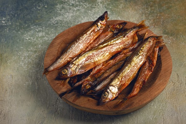 Cold smoked capelin, on a wooden bowl, top view, no people