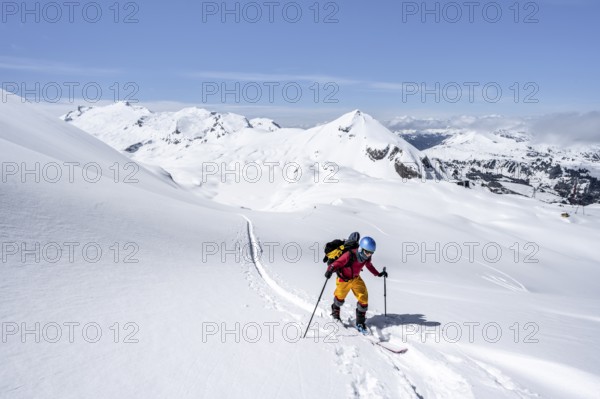 Ski tourer in mountain landscape with snow, behind summit Mittaghorn and Wildhorn, ascent to