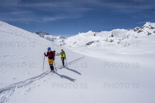 Ski tourers in a mountain landscape with snow, summit Wildhorn in the background, ascent to