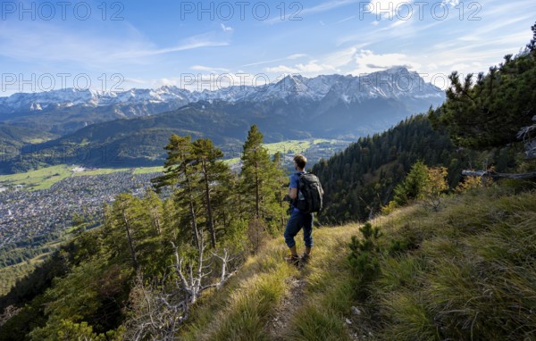 View of mountain panorama with Wetterstein mountains, mountaineer on hiking trail to Kramerspitz,
