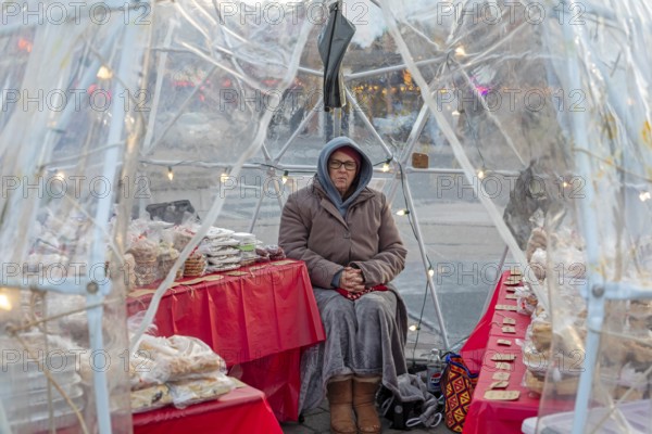 London, Ontario, Canada - A woman sells cookies and pastries on a cold day outside Covent Garden
