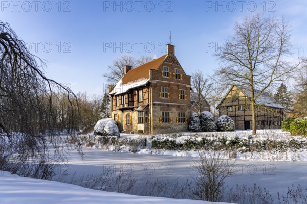The snow-covered moated castle Haus Bisping in winter, Drensteinfurt, Münsterland, North