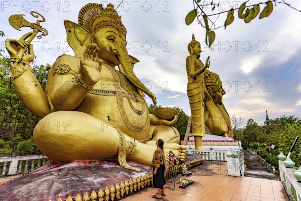 Tourist in front of the huge golden Ganesha statue of the Buddhist temple Wat Mokkanlan in Chom